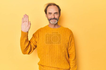 Téléchargez les photos : Blanc homme d'âge moyen en studio jaune souriant gai montrant numéro cinq avec les doigts. - en image libre de droit