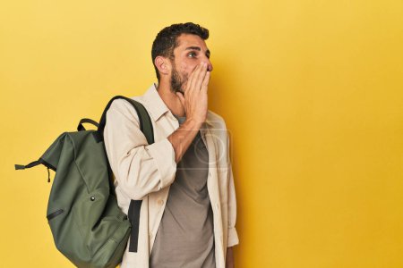 Téléchargez les photos : Jeune homme hispanique avec sac à dos de voyage criant et tenant la paume près de la bouche ouverte. - en image libre de droit