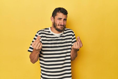 Photo for Young Hispanic man on yellow background showing that she has no money. - Royalty Free Image