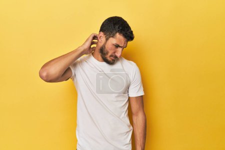 Foto de Joven hispano sobre fondo amarillo sufriendo dolor de cuello debido a estilo de vida sedentario. - Imagen libre de derechos