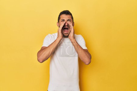 Téléchargez les photos : Jeune homme hispanique sur fond jaune criant excité à l'avant. - en image libre de droit