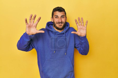 Photo for Young Hispanic man on yellow background receiving a pleasant surprise, excited and raising hands. - Royalty Free Image