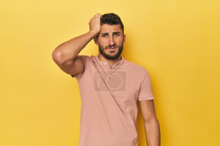 Photo for Young Hispanic man on yellow background tired and very sleepy keeping hand on head. - Royalty Free Image