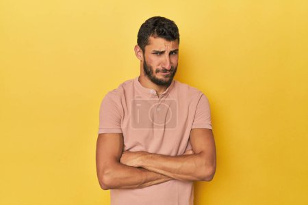 Photo for Young Hispanic man on yellow background unhappy looking in camera with sarcastic expression. - Royalty Free Image