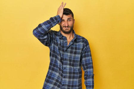 Photo for Young Hispanic man on yellow background forgetting something, slapping forehead with palm and closing eyes. - Royalty Free Image
