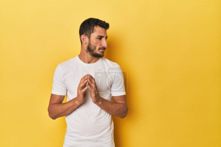 Photo for Young Hispanic man on yellow background making up plan in mind, setting up an idea. - Royalty Free Image