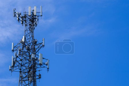 Foto de Una fotografía de la parte superior de una torre de antena celular contra un cielo azul con espacio para copias - Imagen libre de derechos