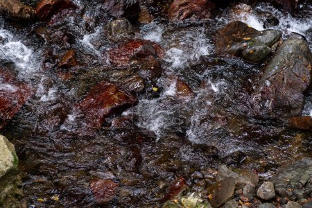Foto de Acercamiento del agua que fluye sobre rocas piedra de cascadas. - Imagen libre de derechos