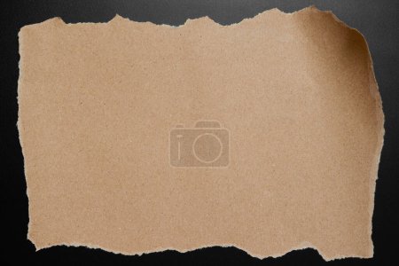 Foto de Agujero moderno rasgado marrón arrugado sobre fondo negro hoja vacía con sombras de luz para papel pintado creativo, tarjeta, diseño de obra de arte. - Imagen libre de derechos