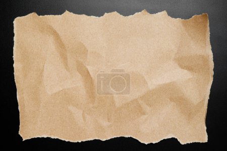 Téléchargez les photos : Papier brun froissé sur fond noir - en image libre de droit