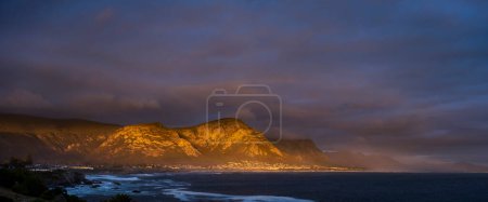 Photo for Evening view from Gearing's Point of the beautiful Kleinrivier Mountains bathed in the last glorious rays of sunlight. Hermanus, Whale Coast, Overberg, Western Cape, South Africa. - Royalty Free Image