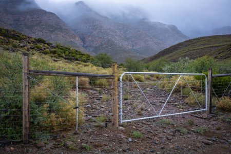 Téléchargez les photos : Ferme et les montagnes Swartberg dans des conditions de ciel couvert sauvage et venteux. Près de Klaarstroom et De Rust. Western Cape. Afrique du Sud - en image libre de droit
