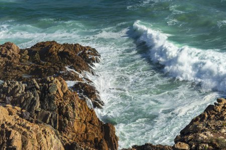 Vista aérea de las olas del océano rompiendo en la escarpada costa rocosa a lo largo de Clarence Drive entre Gordons Bay y Rooi-Els cerca de Cape Town, Western Cape. Sudafrica