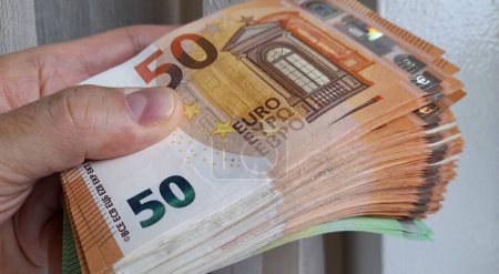 50-Euro-Scheine in den Händen eines Mannes - Reichtum