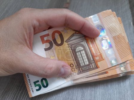 Billets de 50 euros entre les mains d'un homme - richesse
