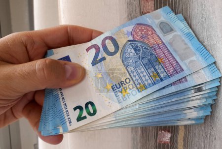 20 billets en euros entre les mains d'un homme - richesse