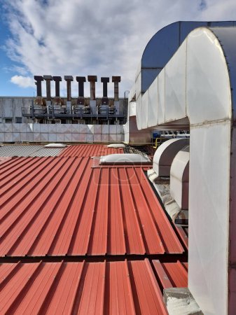 Technische Anlage auf dem alten Dach eines Industriegebäudes aus Wellblech