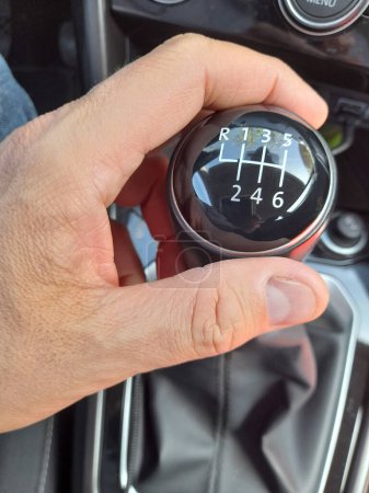 A MAN'S HAND ON THE GEAR LEVER OF THE CAR