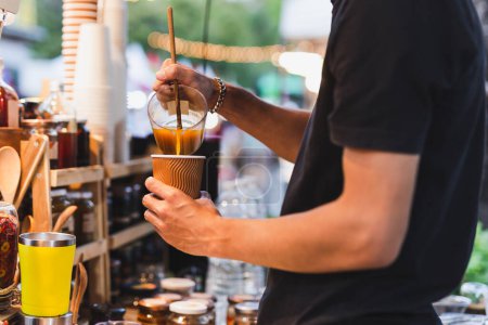 Foto de Man barista making healthy latte with turmeric drink at counter bar cafe outdoor - Imagen libre de derechos