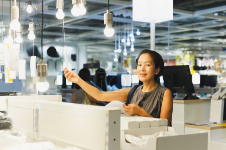 Energy efficient lighting choice: Woman holding and choosing a LED light bulb
