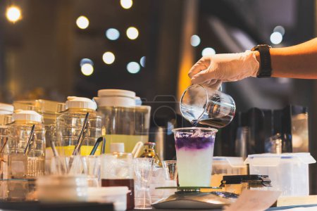 Téléchargez les photos : Homme faisant du thé papillon avec du jus de yuzu dans un tak away verres - en image libre de droit