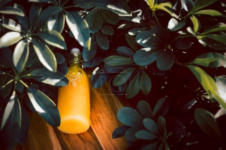 Téléchargez les photos : Vue de dessus jus d'orange frais dans une bouteille en verre se trouve sur un fond en bois - en image libre de droit