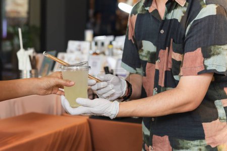 Téléchargez les photos : Homme barista portant des bosquets servant à boire au client dans le café. - en image libre de droit