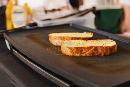 Téléchargez les photos : Tranche de pain à l'ail sur la poêle chaude - en image libre de droit