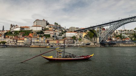 Foto de Barco rebelde típico en el río douro con la ciudad de Oporto (Portugal) como fondo - Imagen libre de derechos