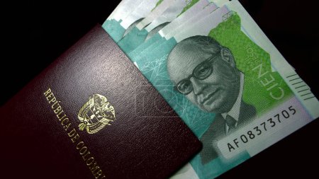 Abanico de billetes colombianos pesos dentro de un pasaporte colombiano COP
