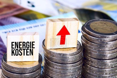 Téléchargez les photos : Gros plan des piles de pièces en euros avec inscription des coûts énergétiques en allemand - en image libre de droit