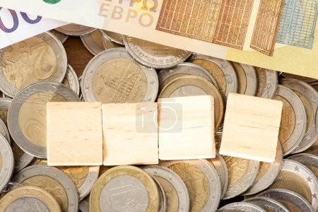 Téléchargez les photos : Cubes en bois sur pile de pièces en euros - en image libre de droit