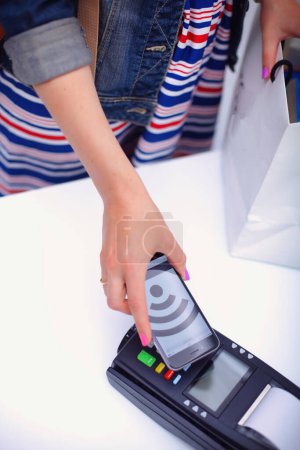 Photo for Customer is paying with smartphone in shop using NFC technology. NFC technology. Customer is paying. - Royalty Free Image