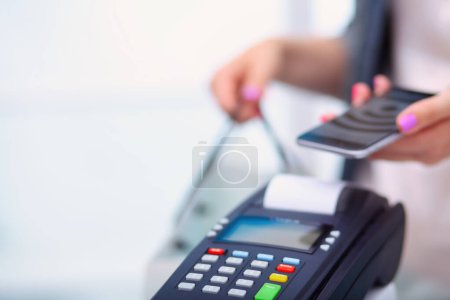 Photo for Customer is paying with smartphone in shop using NFC technology. NFC technology. Customer is paying. - Royalty Free Image