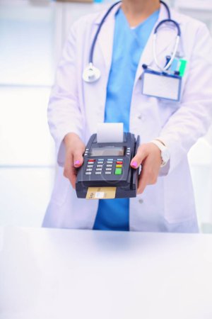 Photo for Doctor is holding payment terminal in hands. Paying for health care. Doctor. - Royalty Free Image