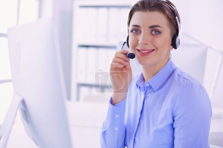 Photo for Serious pretty young woman working as support phone operator with headset in office. - Royalty Free Image