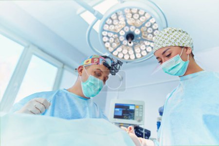 Téléchargez les photos : Chirurgien d'équipe au travail en salle d'opération. - en image libre de droit