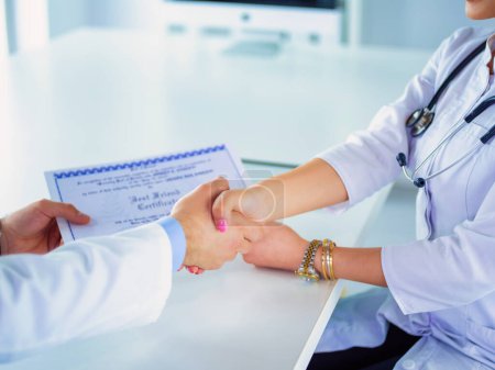 Téléchargez les photos : Le médecin serre la main d'un patient isolé sur fond blanc. - en image libre de droit