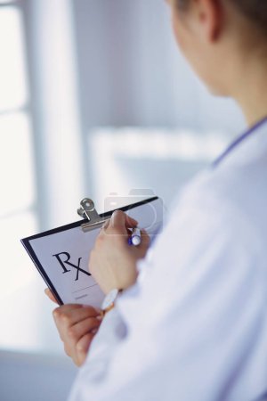 Foto de La doctora tiene un documento de prescripción en blanco. oficina Hospital. - Imagen libre de derechos