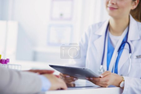 Téléchargez les photos : Médecin féminin utilisant une tablette dans le hall de l'hôpital, souriant
. - en image libre de droit