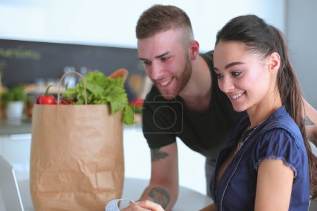 Téléchargez les photos : Couple payer leurs factures avec ordinateur portable dans la cuisine à la maison
. - en image libre de droit