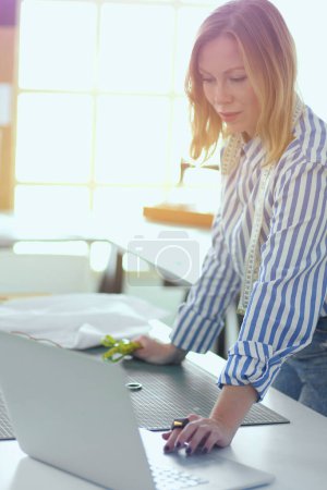 Photo for Fashion designer working on her designs in the studio. - Royalty Free Image