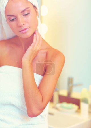 Photo for Young attractive woman standing in front of bathroom mirror. - Royalty Free Image