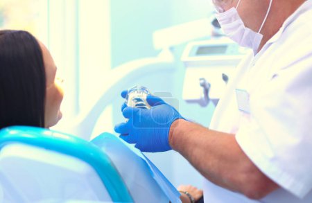 Téléchargez les photos : Image de jeune femme avec dentiste sur elle avant de vérifier la cavité buccale. - en image libre de droit