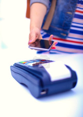 Foto de El cliente está pagando con el teléfono inteligente en la tienda utilizando la tecnología NFC. Tecnología NFC. Cliente está pagando
. - Imagen libre de derechos