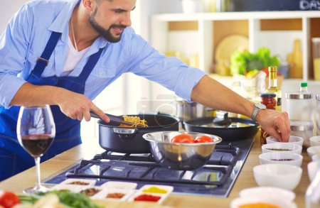 Téléchargez les photos : Homme préparant des aliments délicieux et sains dans la cuisine de la maison. - en image libre de droit