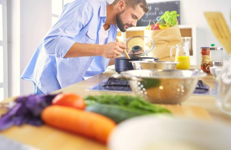 Foto de Hombre preparando comida deliciosa y saludable en la cocina casera. - Imagen libre de derechos