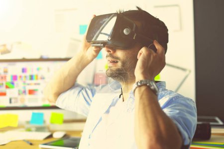 Téléchargez les photos : Jeune programmeur de logiciels masculins testant une nouvelle application avec des lunettes de réalité virtuelle 3d au bureau - en image libre de droit