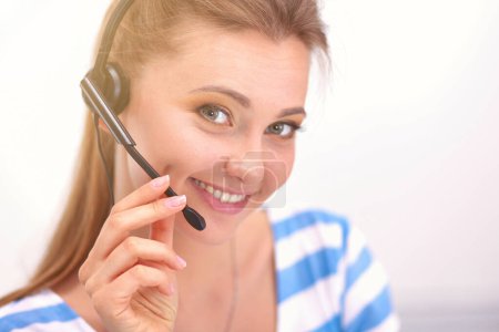 Téléchargez les photos : Femme souriante avec des documents assis sur le bureau avec ordinateur portable - en image libre de droit