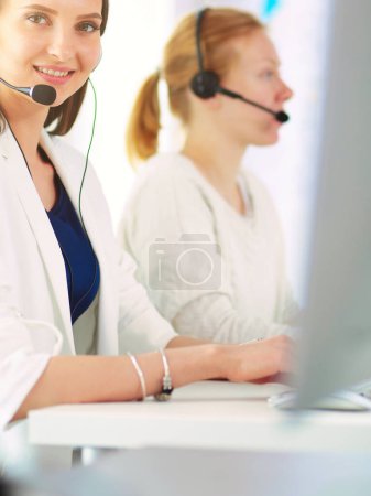 Téléchargez les photos : Femme d'affaires souriante ou opérateur de ligne d'assistance avec casque et ordinateur au bureau. - en image libre de droit